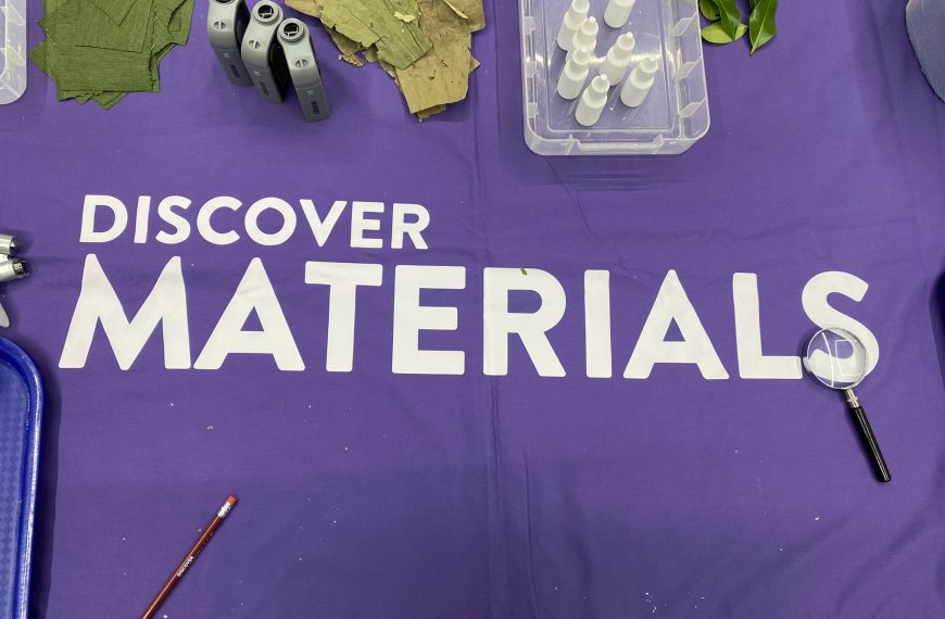 Discover Materials Logo printed on a tablecloth with a range of outreach materials.